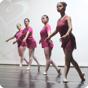4 bailarinas em ensaio, todas usam roupas rosa com o logotipo da Associação Fernanda Bianchini